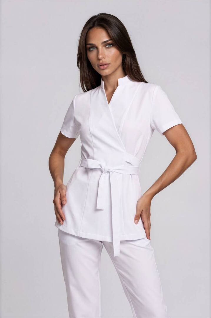 IMG_9309-Emmi-Light Studio-2 Luxury esthetician wearing the Riviera White Wrap Tunic in a modern spa and wellness environment.
